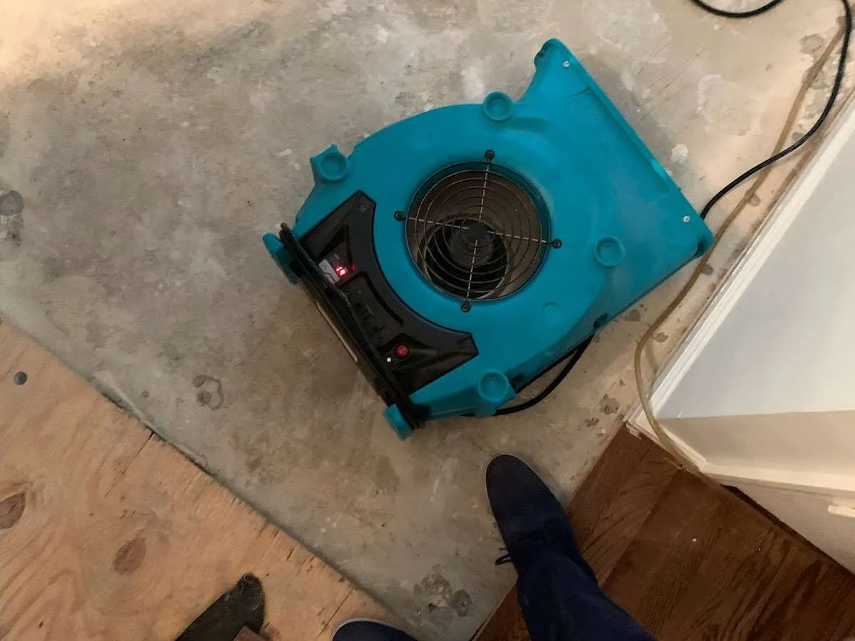 Air mover drying subfloor during Commercial Water Damage Restoration in Henniker